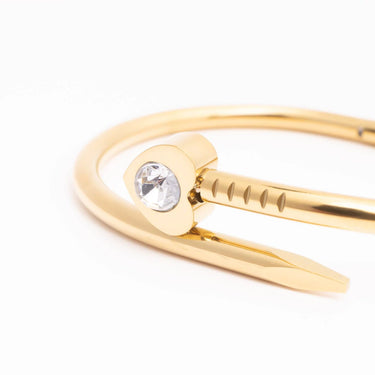 Gold bracelet with a clear gemstone on a white background