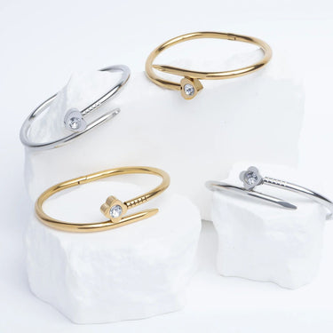 Set of gold and silver bangle bracelets on a white surface