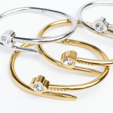 Gold and silver bangles with gemstones on a white background