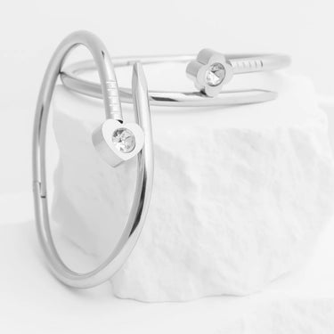 Silver bracelet with heart-shaped charms on a light gray background