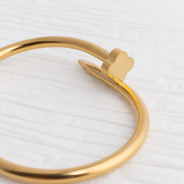 Gold bracelet with a heart charm on a white background
