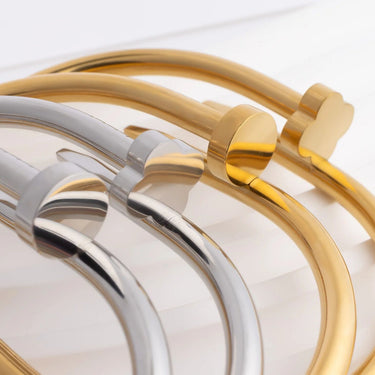 Four gold and silver bracelets on a light background