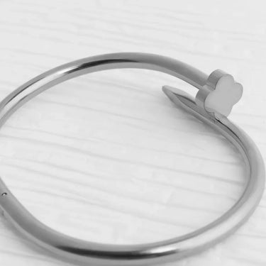 Silver ring with a heart-shaped component on a white background