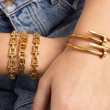 Gold bracelets on a person's wrist with denim background