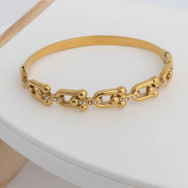 Gold chain bracelet on a white surface
