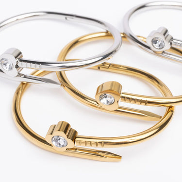 Gold and silver bangles with crystal accents on a white background