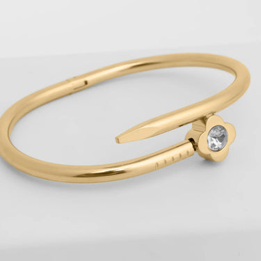 Gold ring with a small diamond on a light gray background