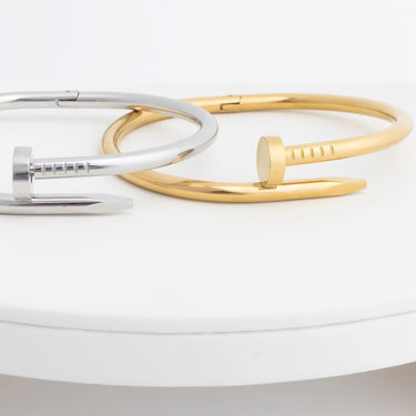 Gold and silver bangles on a white surface