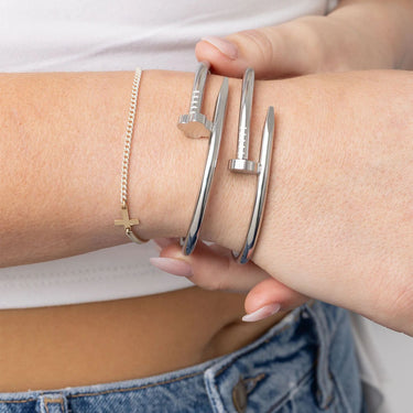 Silver bangles on a wrist with a blurred background