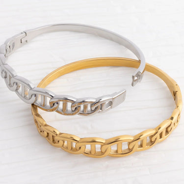 Two chain-link bracelets, one gold and one silver, on a white background