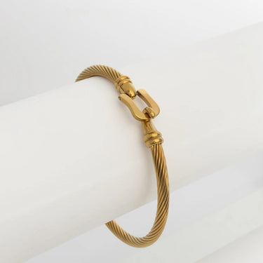 Gold bracelet with a buckle clasp on a white background