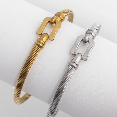 Gold and silver buckle clasp cable bracelets on a white surface