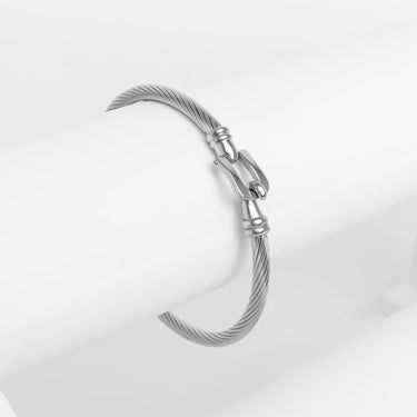 Silver bracelet with buckle clasp on a light gray background