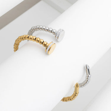 Two gold and silver earrings on a white surface