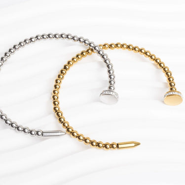 Two beaded bracelets, one gold and one silver, on a white background.