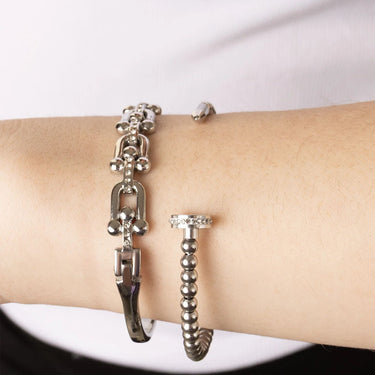 Silver bracelet and ring on a wrist against a white background