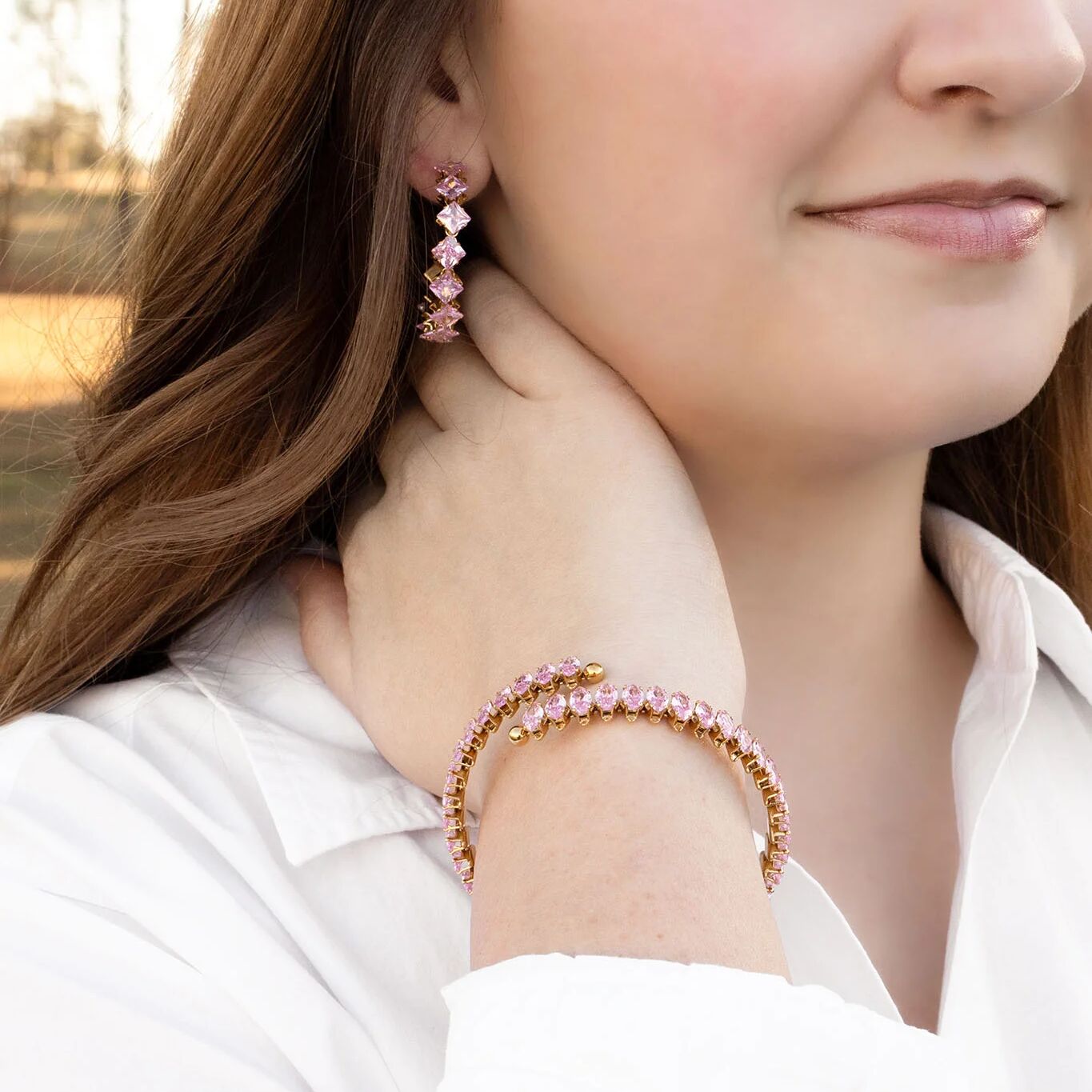 Close-up of a woman wearing pink beaded earrings and bracelet.