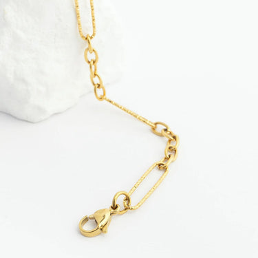 Gold chain necklace with a heart-shaped clasp on a white background