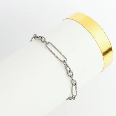 Gold bracelet and silver chain on a white background