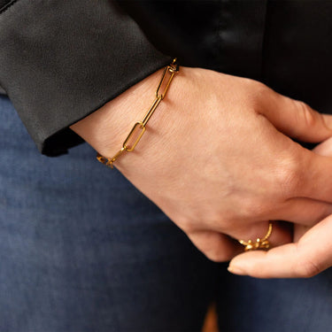 Gold bracelet on a wrist with a blurred background
