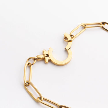 Gold bracelet with a unique clasp design on a white background