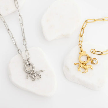 Gold and silver necklaces with horse charms on a white background