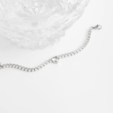 Silver bracelet with a heart-shaped clasp on a white background