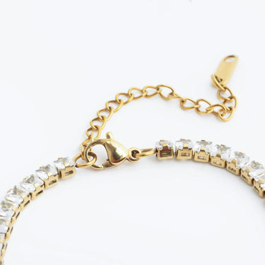 Gold bracelet with clear stones on a white background