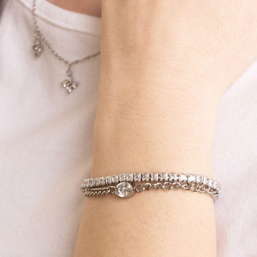 Close-up of a wrist wearing a silver bracelet with a delicate chain design.