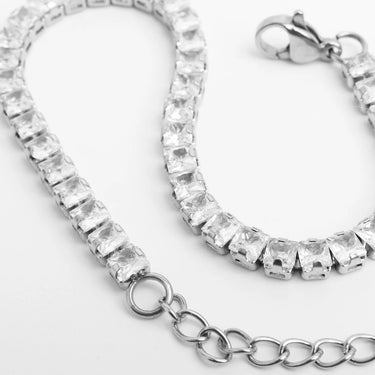 Silver bracelet with clear gemstones on a light gray background