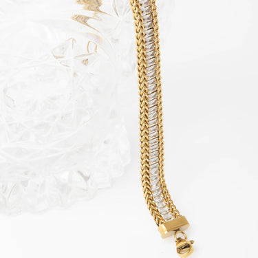 Gold chain bracelet with clear crystals on a white background