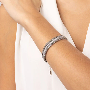 Silver bracelet on a person's wrist against a white background