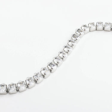 Silver bracelet with clear gemstones on a white background