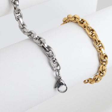 Two chain bracelets, one silver and one gold, on a white background.