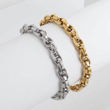 Two chain bracelets, one silver and one gold, on a white background