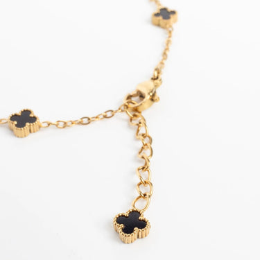 Gold Small Floral Motif Bracelet  with black clover-shaped charms on a white background