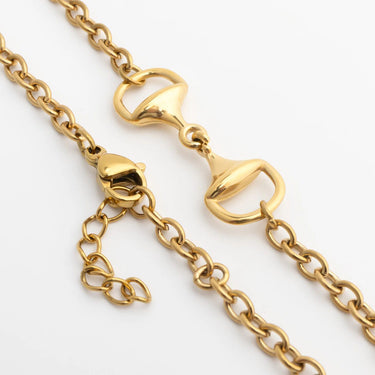 Close-up of a gold Horsebit Bracelet with lobster clasp on a white background
