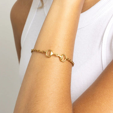 Gold Horsebit Bracelet on a person's wrist with a plain background