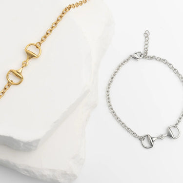 Gold and silver bracelets with horse bit designs on a white background