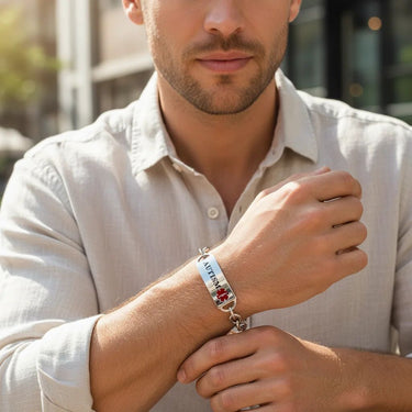 Man wearing a bracelet with a medical symbol on his wrist.