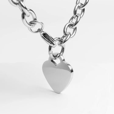 Silver chain necklace with a heart-shaped pendant on a white background