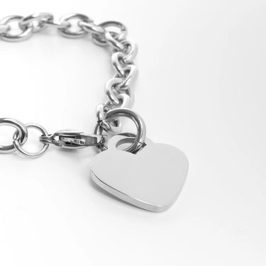 Silver chain bracelet with a heart-shaped tag on a white background