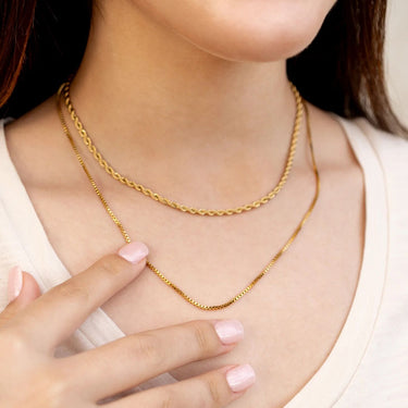Gold chain necklace on a person with a blurred background
