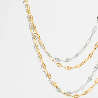 Two gold and silver Lip Belly Chains on a light gray background