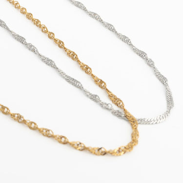 Two gold and silver Singapore Belly Chains on a white background