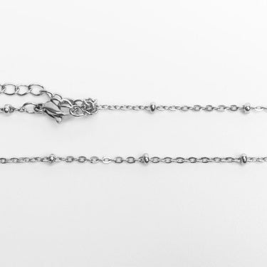 Close-up of a silver Satellite Belly Chain on a white background