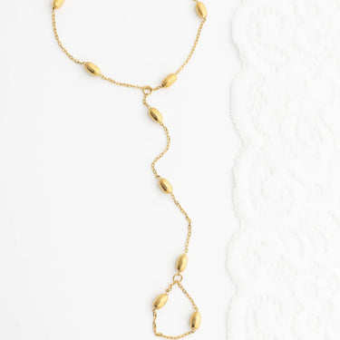 Gold Statement Bead Hand Chain  with teardrop-shaped beads on a white background