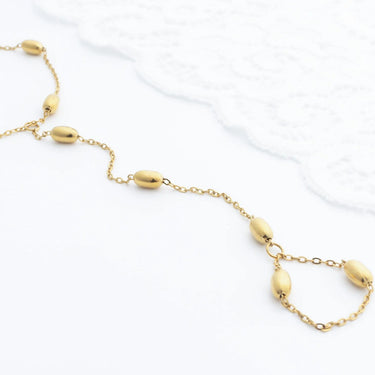 Gold Statement Bead Hand Chain  with round beads on a white background