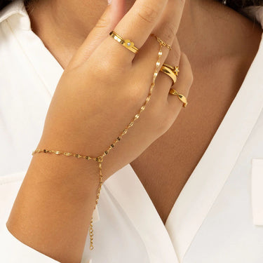 Gold  Lip Hand Chain and rings on a hand against a white background