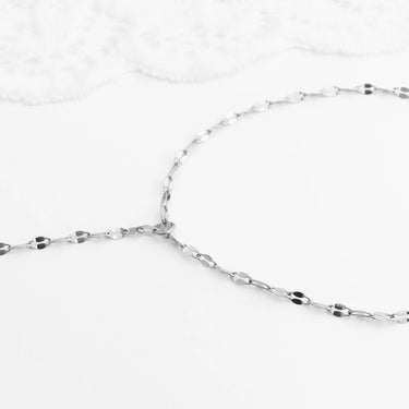 Close-up of a silver  Lip Hand Chain on a white background
